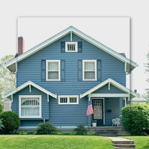 Blue two-story house with white trim, American flag, and front porch.