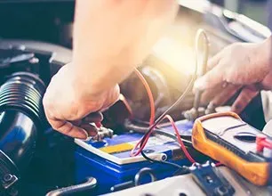 Automotive electrical services image showing technician adjusting automotive wiring
