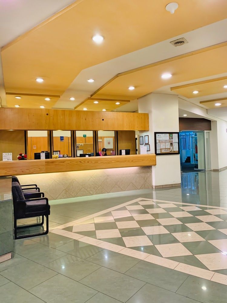 A lobby with a checkered floor and a wooden counter