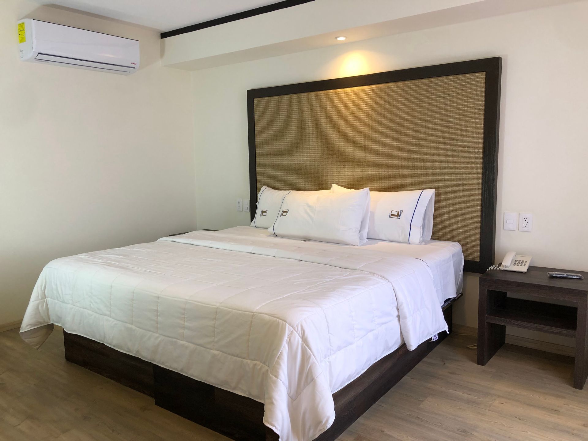 A hotel room with a king size bed and a nightstand