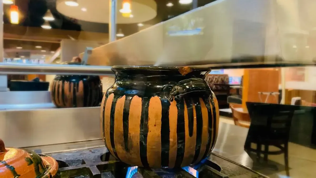 A pumpkin is cooking on a stove in a restaurant.
