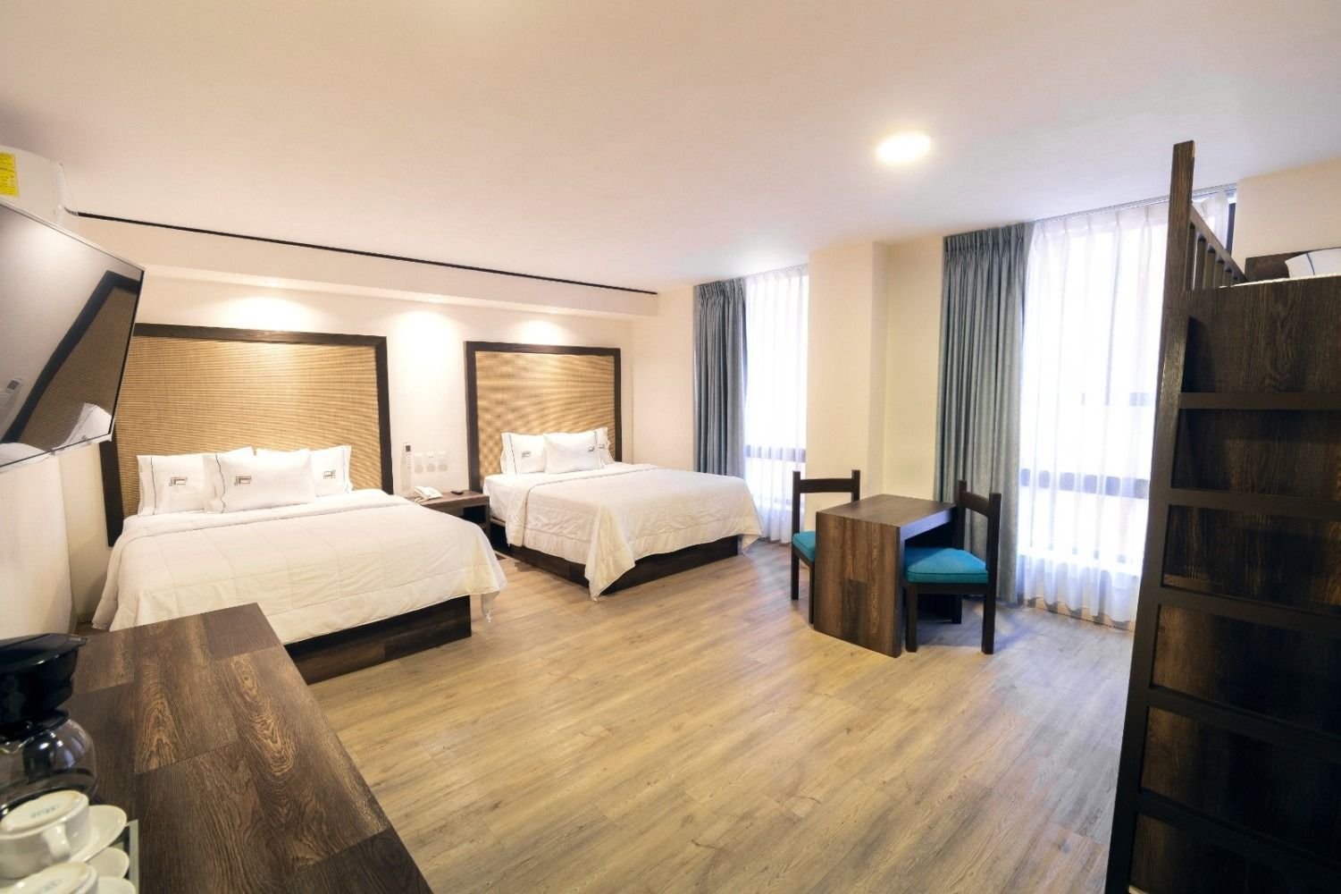 A hotel room with two beds , a table and chairs.