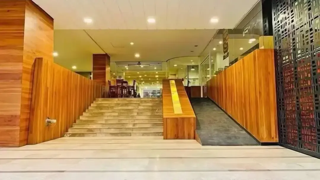A hotel lobby with stairs and a ramp leading up to the lobby.