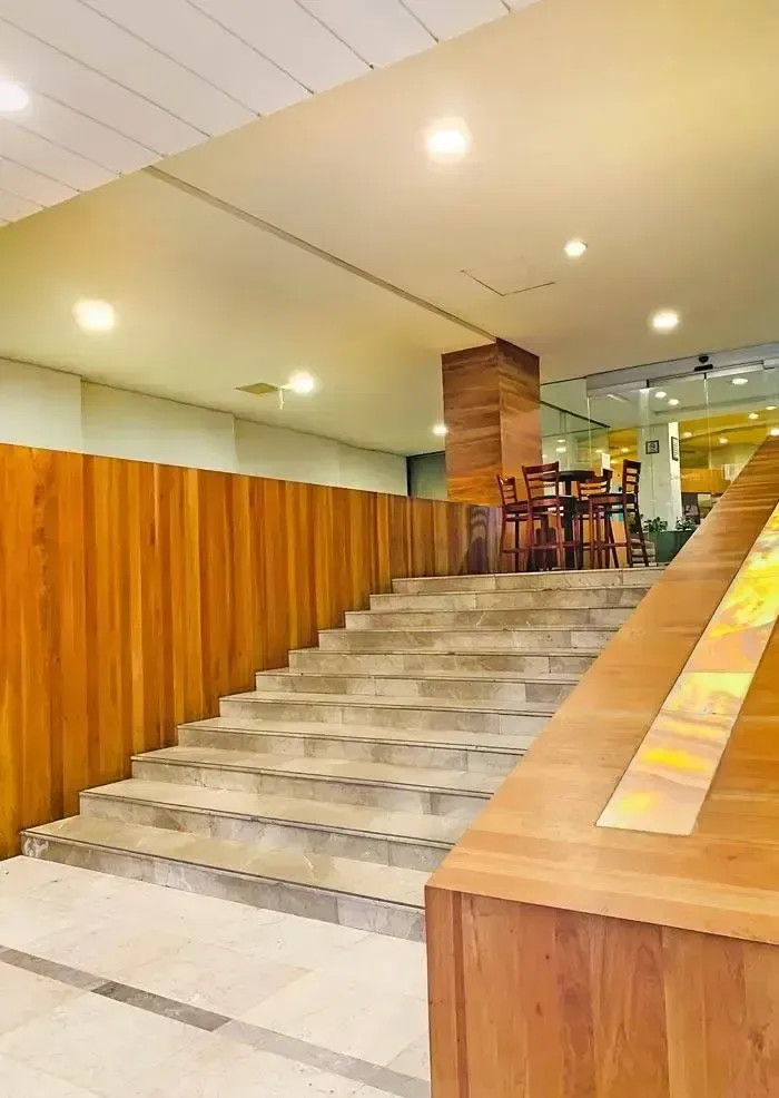 A set of stairs leading up to a restaurant with wooden walls.