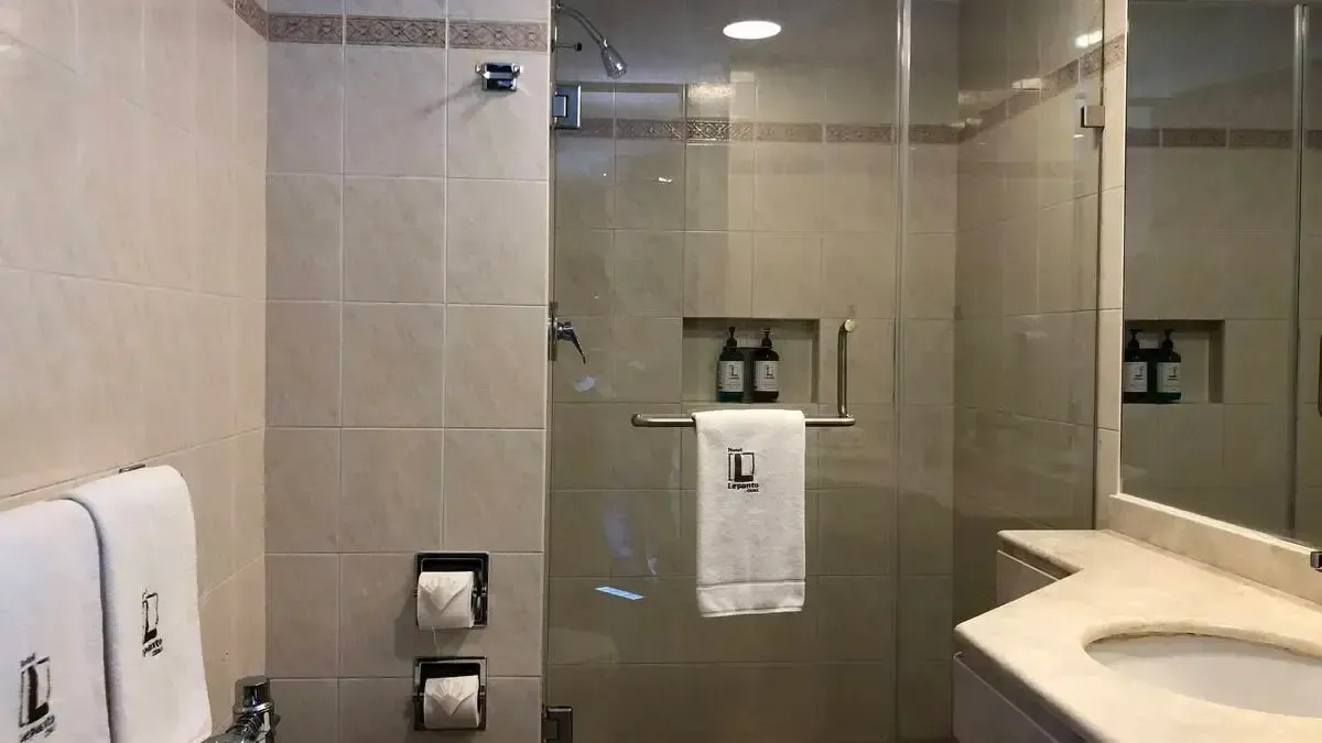 A bathroom with a sink , shower , and mirror.