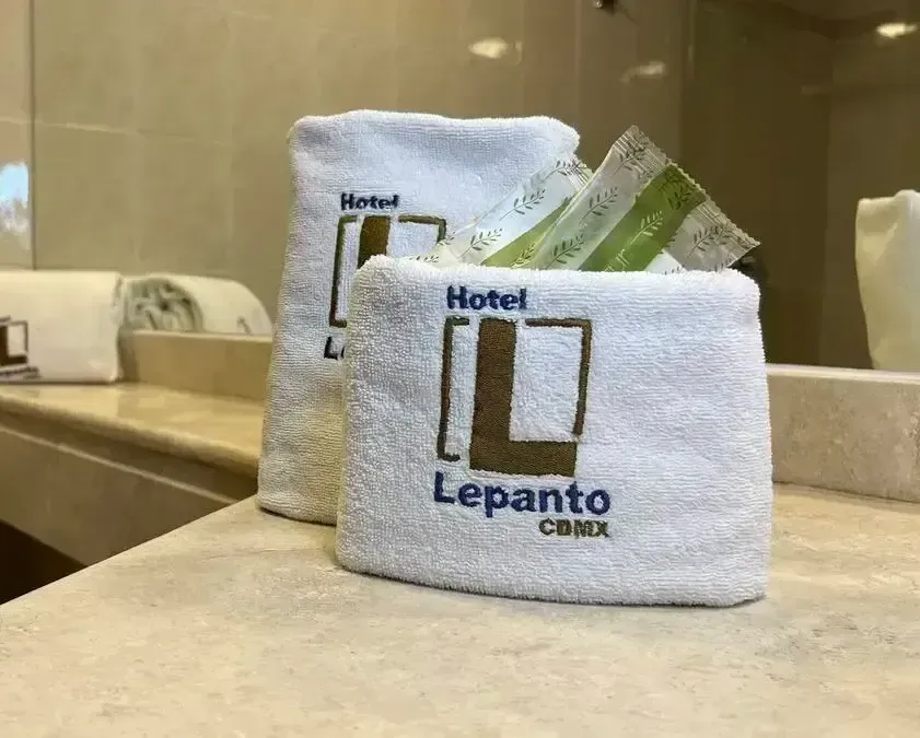 A bathroom with a sink , mirror , and towels on the counter.