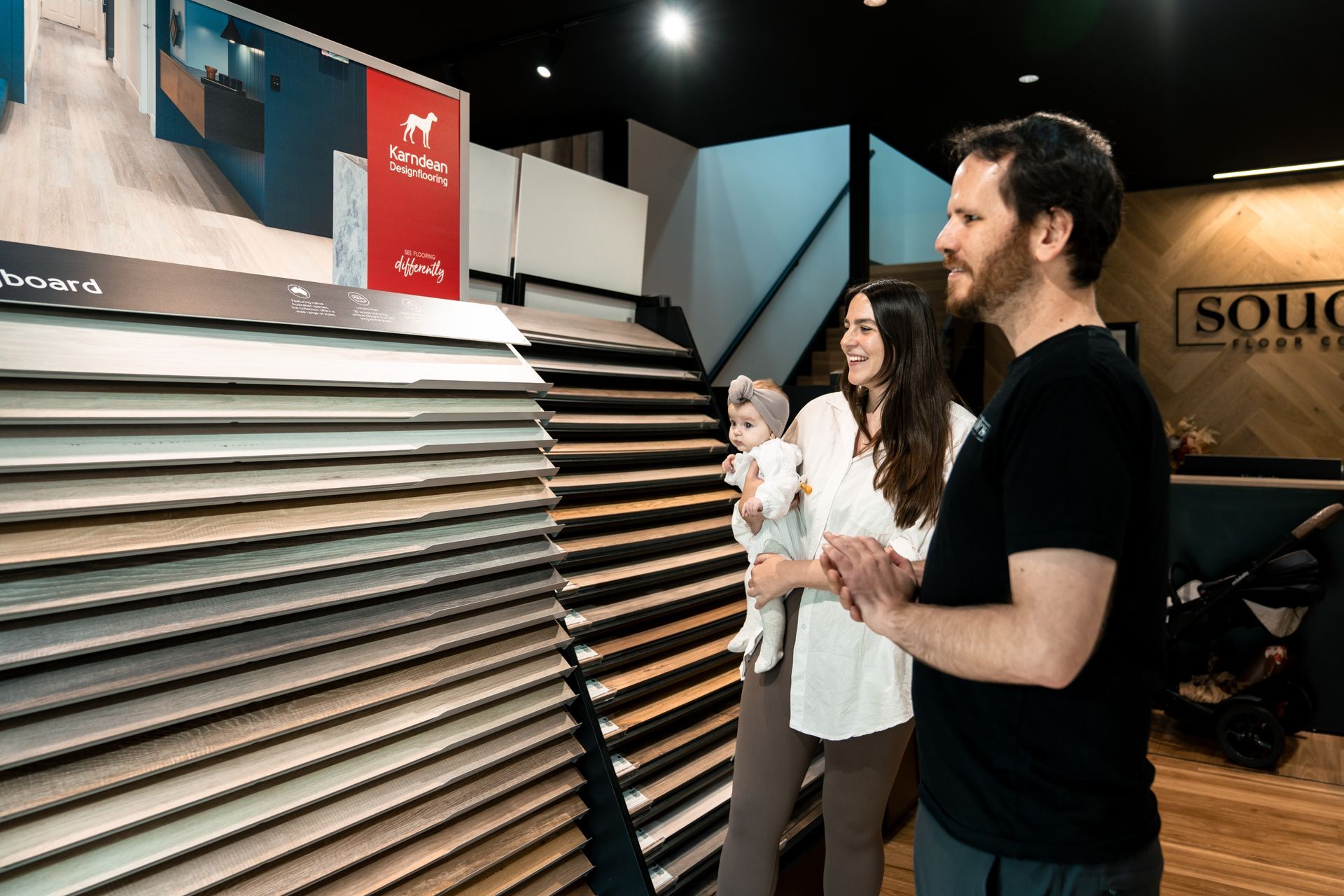 A man and a woman are looking at a display of flooring in a store.