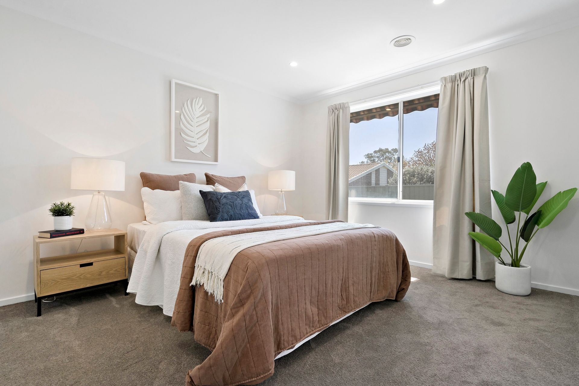 A bedroom with a bed , nightstand , and window.