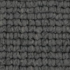 A close up of a gray rug with a brick pattern.