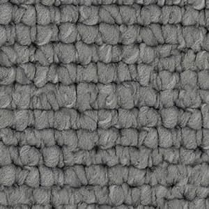 A close up of a gray rug with a knitted pattern.