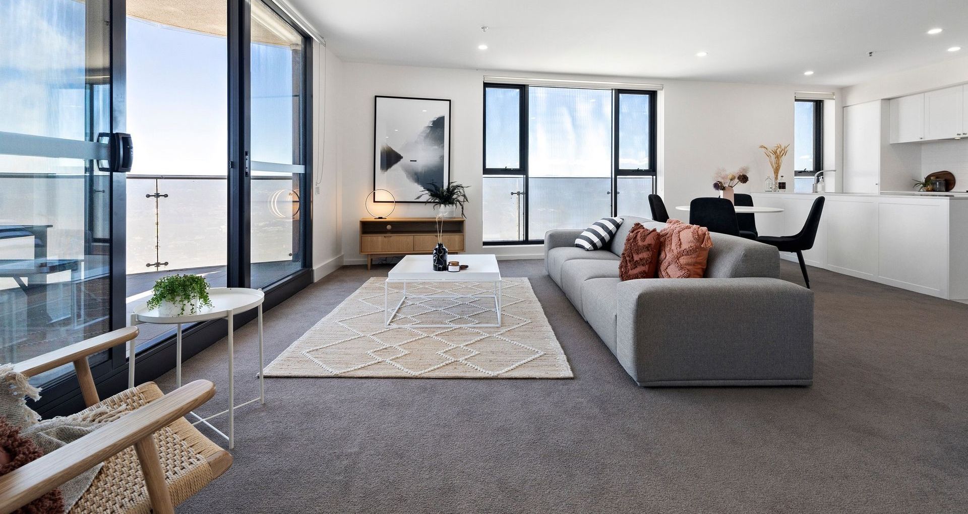 A living room with a couch , table , chairs and a balcony.