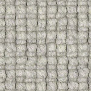 A close up of a white rug with a knitted pattern.