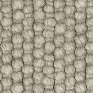 A close up of a rug with a knitted pattern.