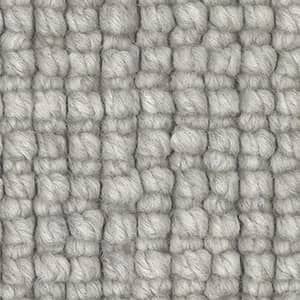 A close up of a gray rug with a knitted pattern.