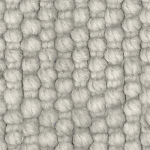 A close up of a white rug with a knitted pattern.