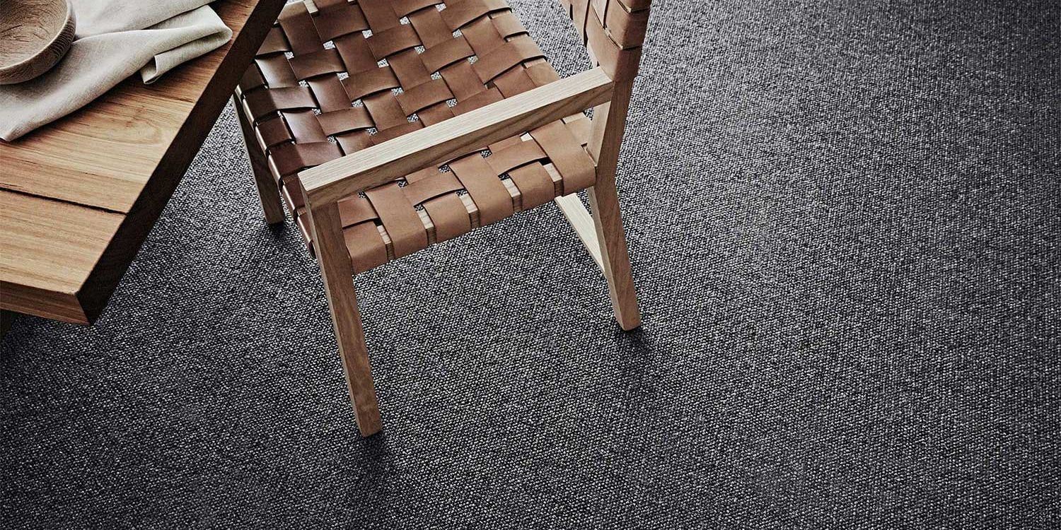 A chair is sitting on a carpet next to a table.