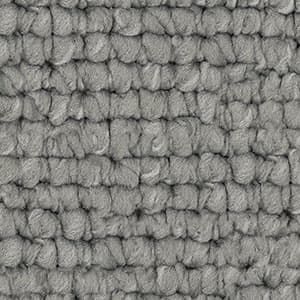 A close up of a gray rug with a knitted pattern.