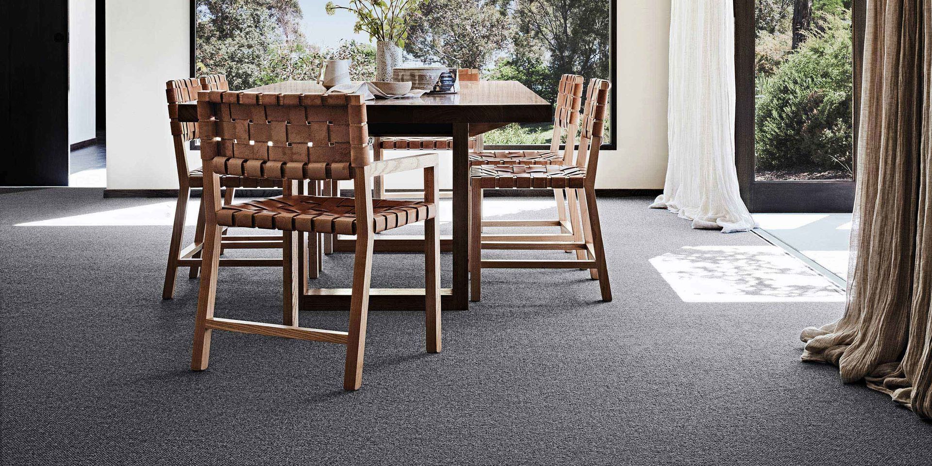 A dining room with a table and chairs on a carpeted floor.