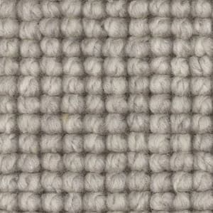 A close up of a carpet with a pattern of balls of yarn.