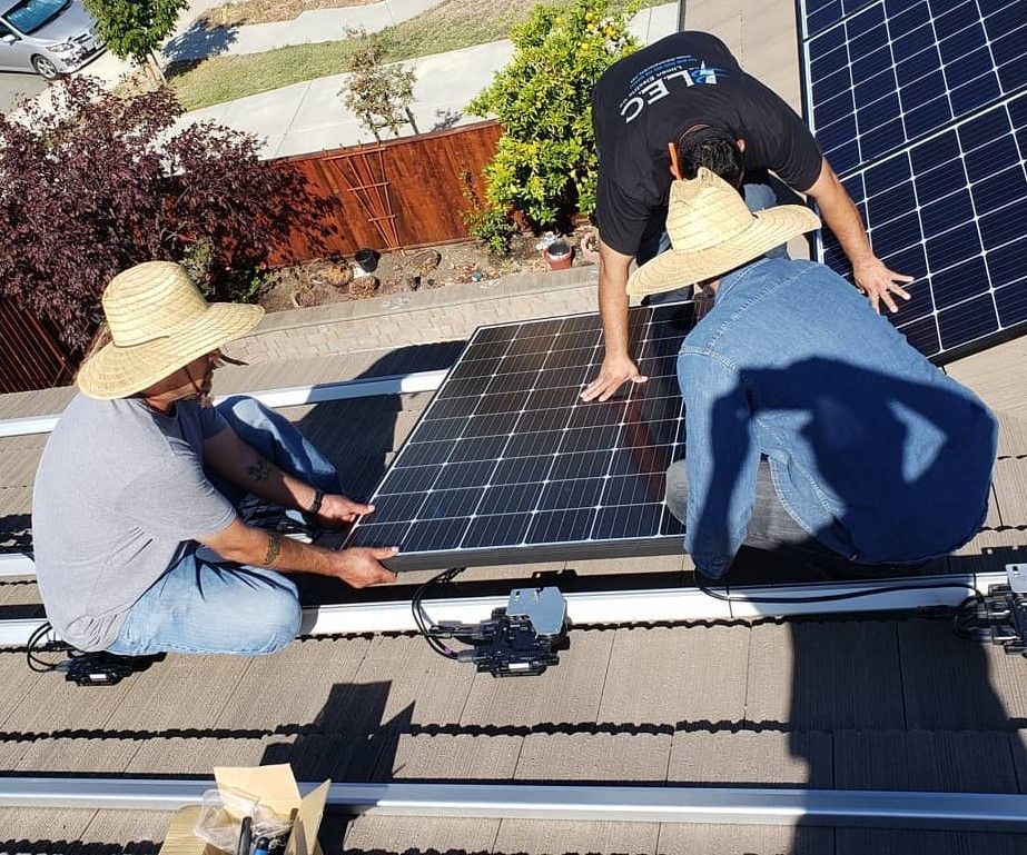 Two men are installing solar panels on a roof