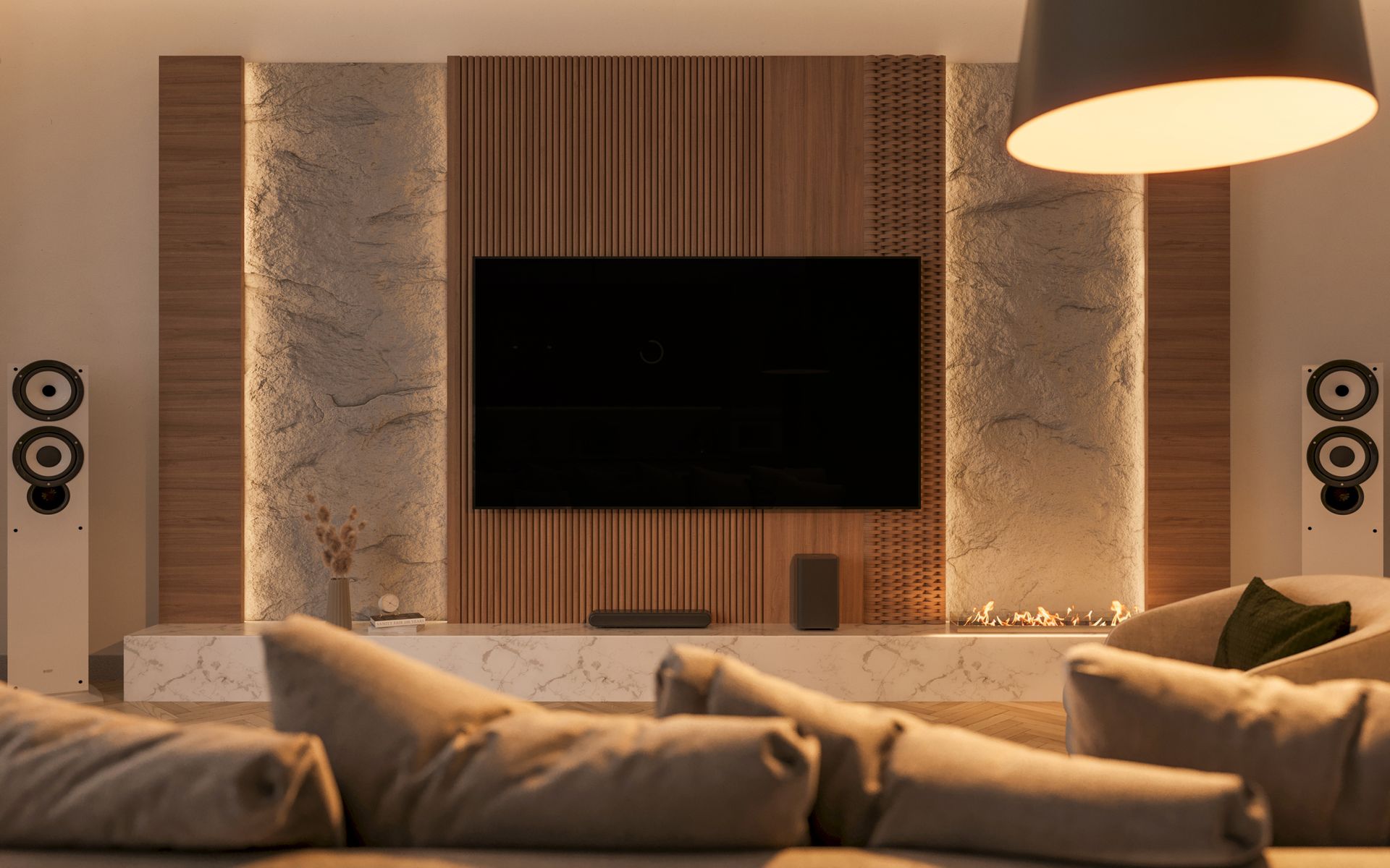 A living room with a couch , chair , speakers and a flat screen tv.