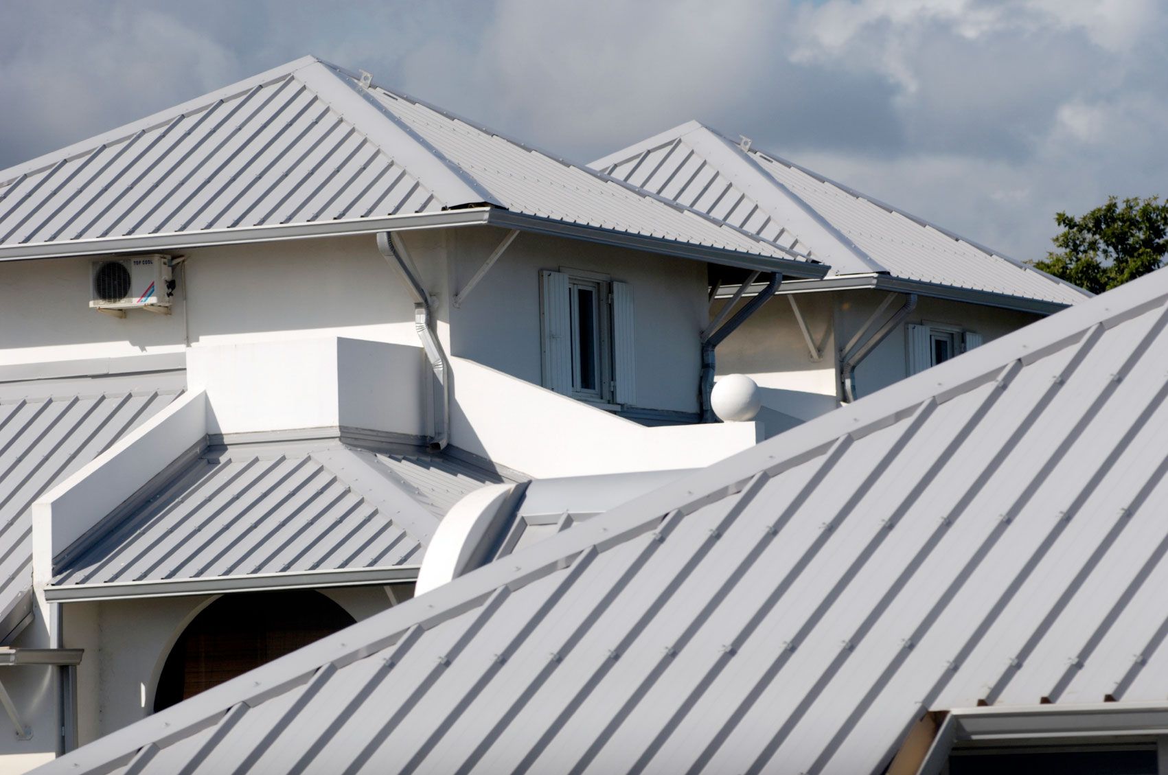 A white house with a silver metal roof