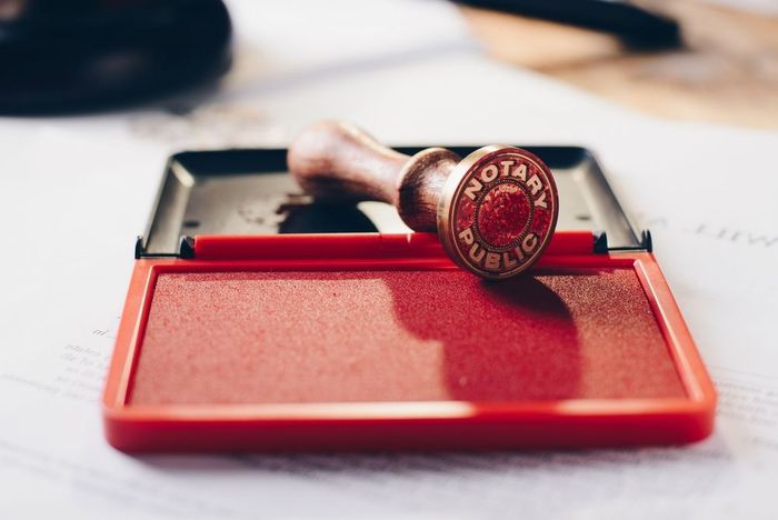 A notary stamp is sitting on top of a red ink pad