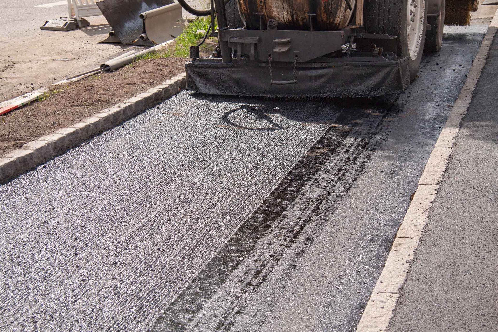 A Machine Is Spreading Asphalt On The Side Of A Road – Melbourne, VIC - Hands On Concrete Vic