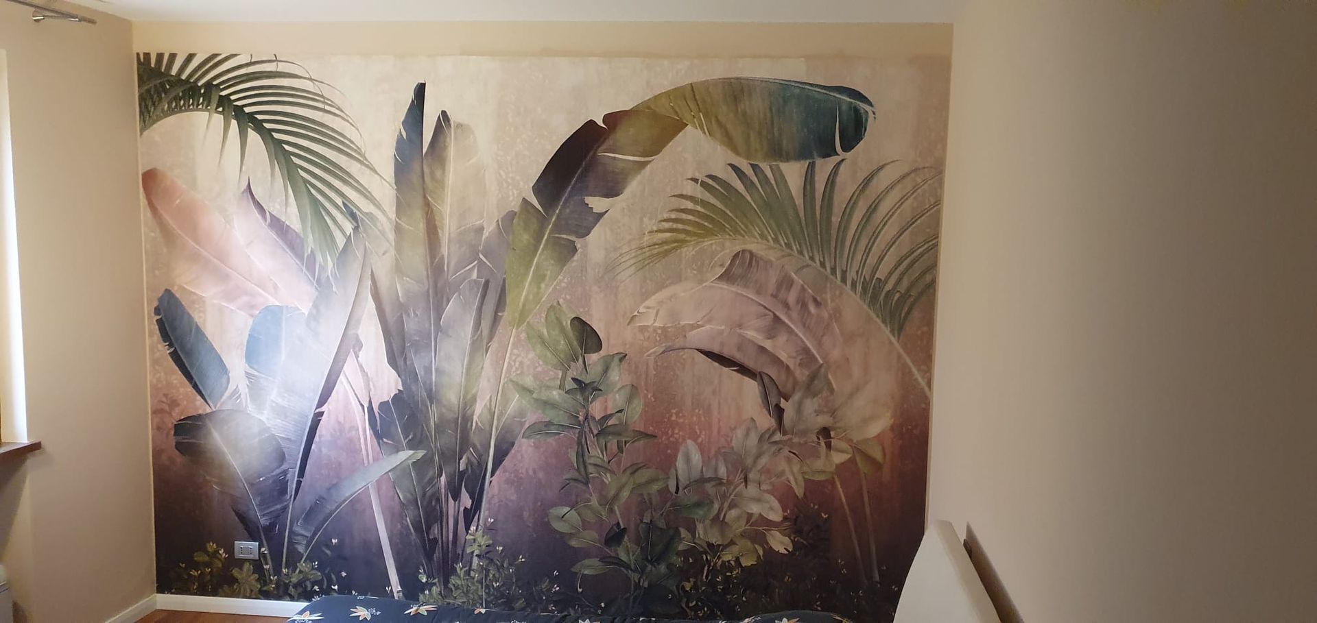 Grande murale raffigurante piante tropicali e foglie di palma in stile acquerello, nelle tonalità del marrone, del verde e del crema.