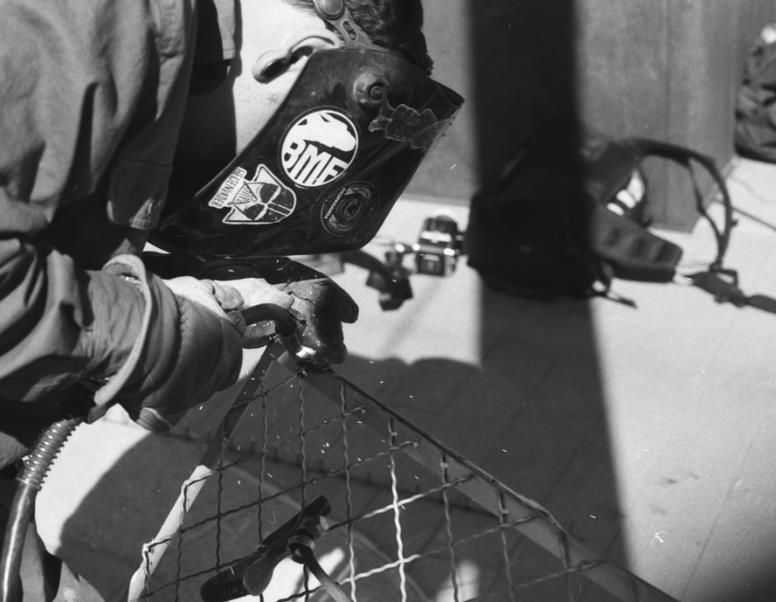 A construction worker is working on a fence at a construction site.
