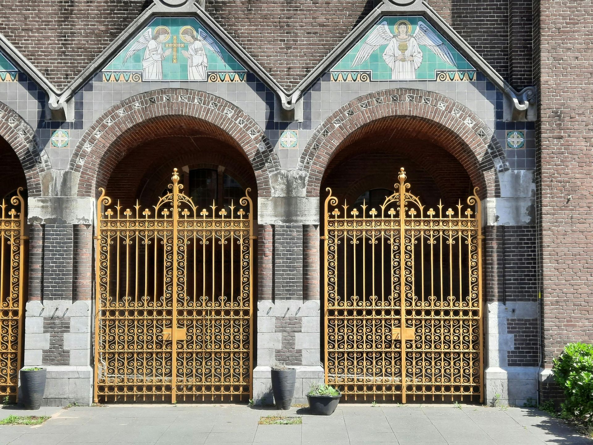 A brick building with arches and gold gates