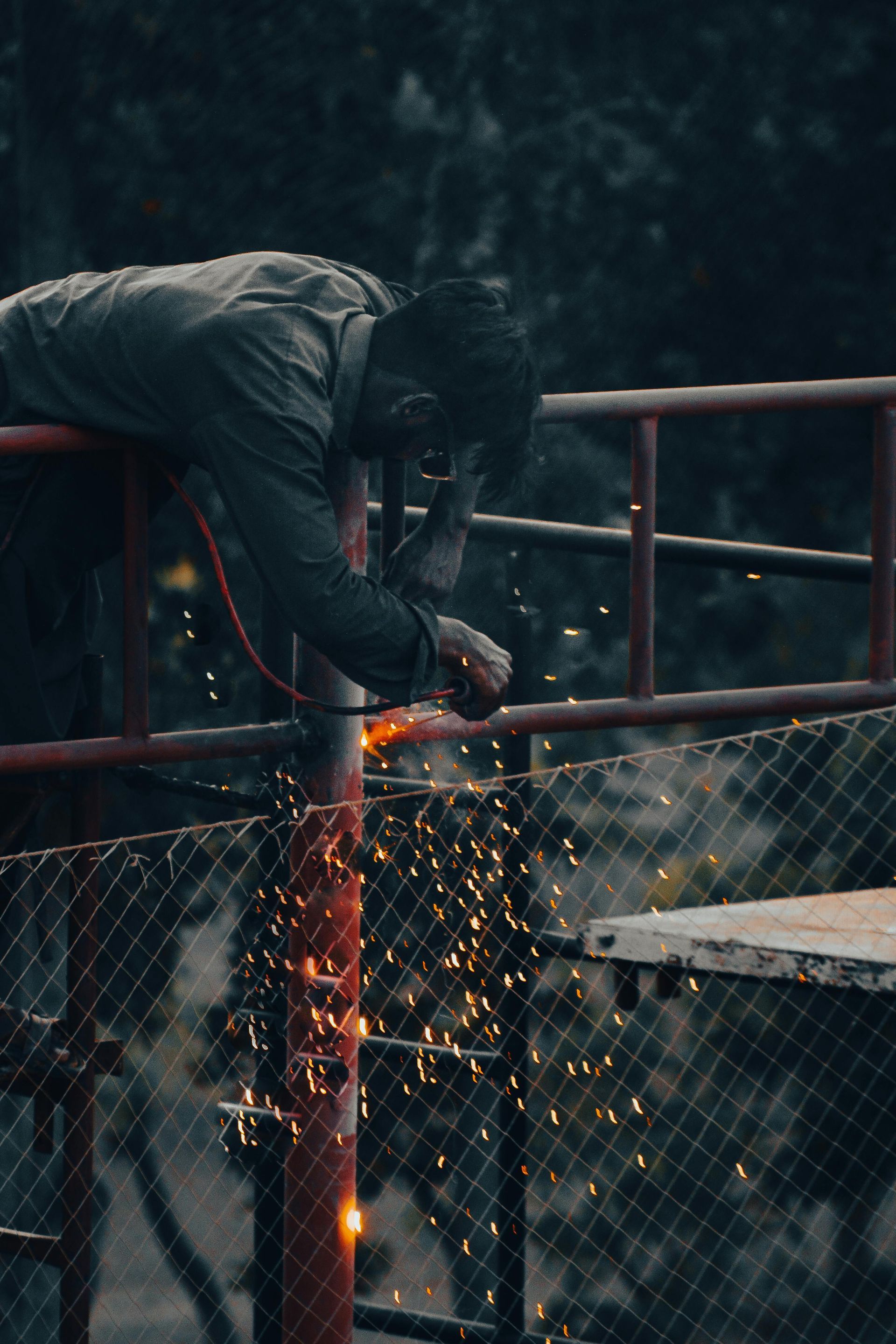 A construction worker is working on a fence at a construction site.