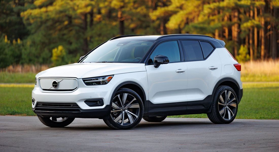 A white volvo xc40 electric suv is parked on the side of a road.