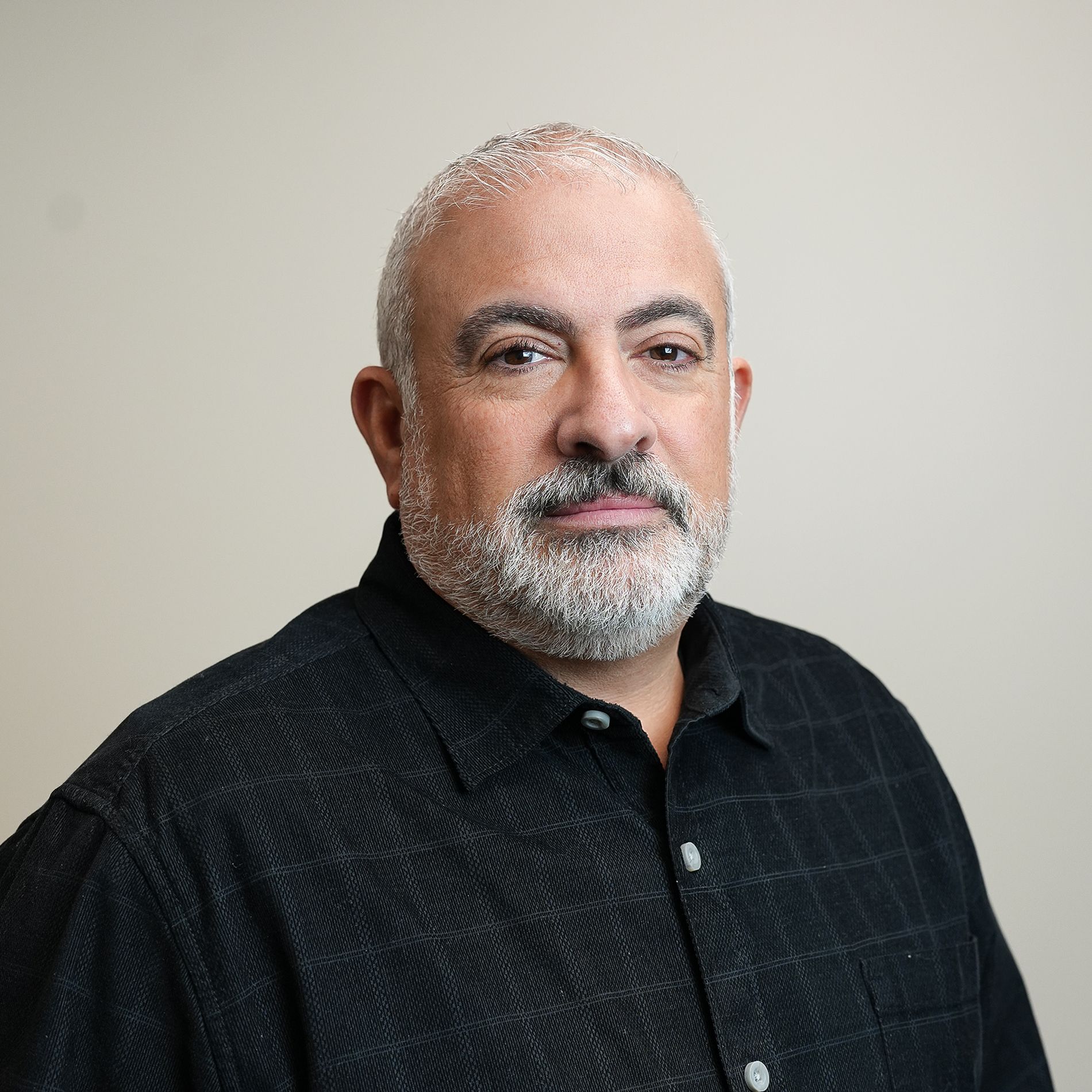 A man and a woman are sitting on a dock overlooking a lake.