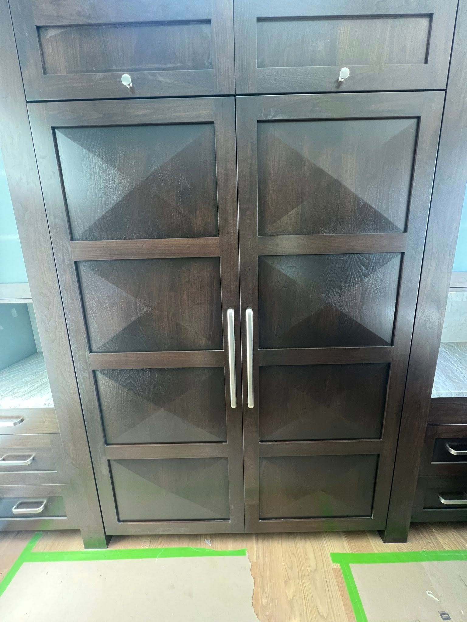 Dark brown wooden cabinet with textured glass panels and silver handles.