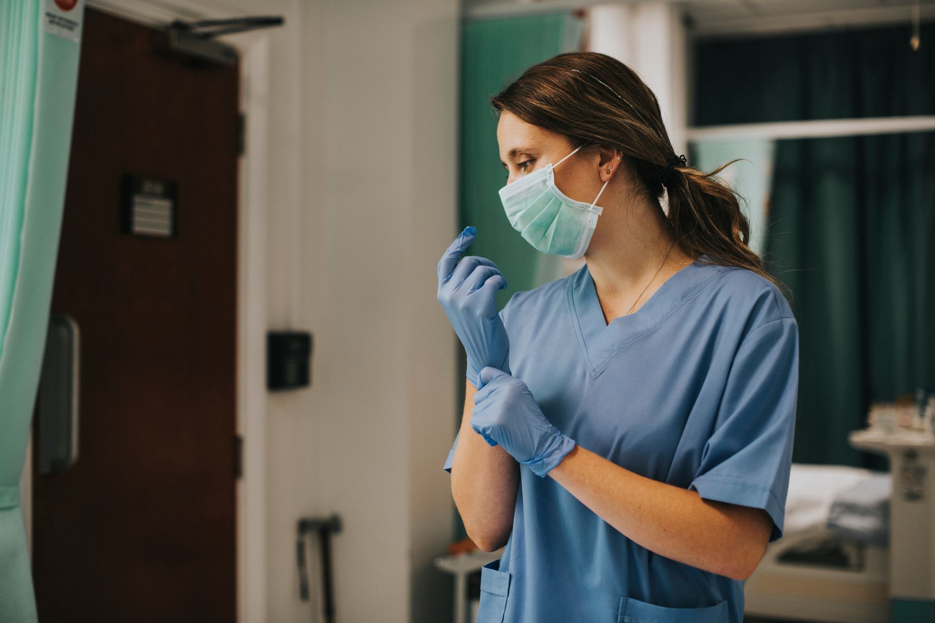 Stock photo of a nurse, prepping her gloves