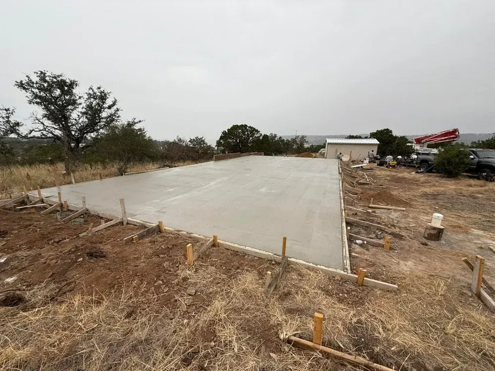 A concrete foundation is being built in a field.