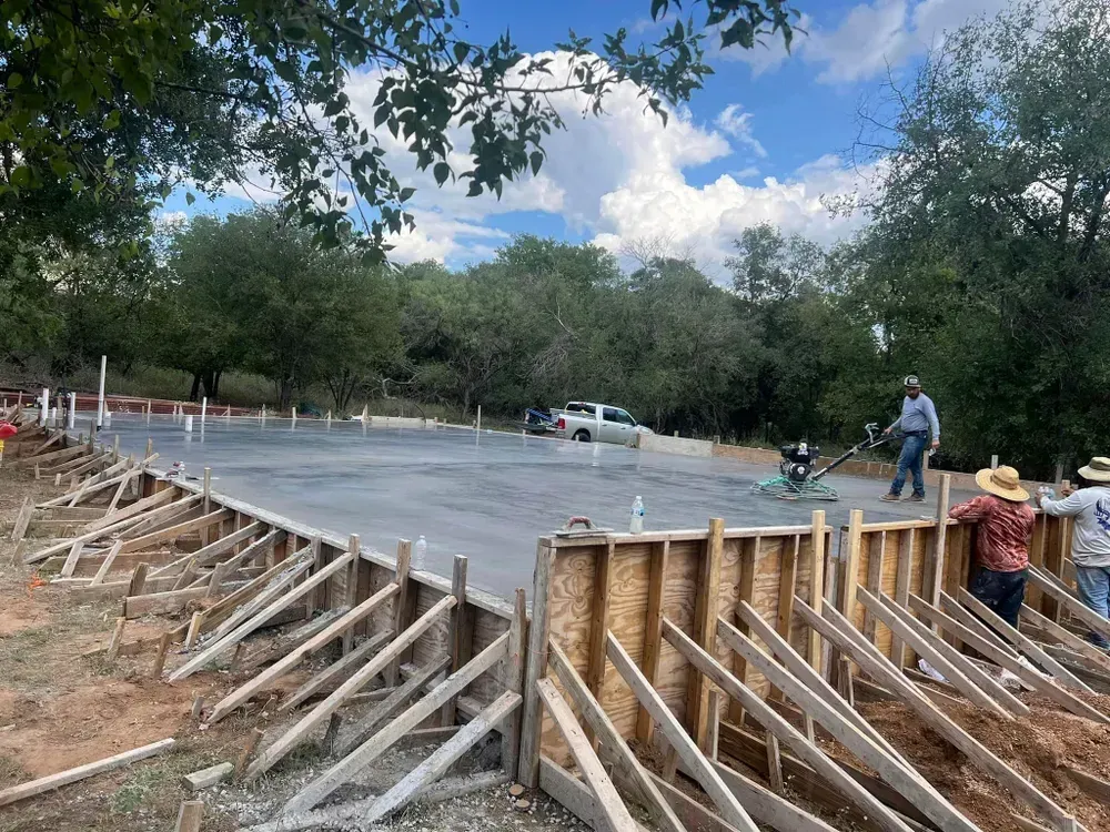 A group of construction workers are working on a concrete floor.
