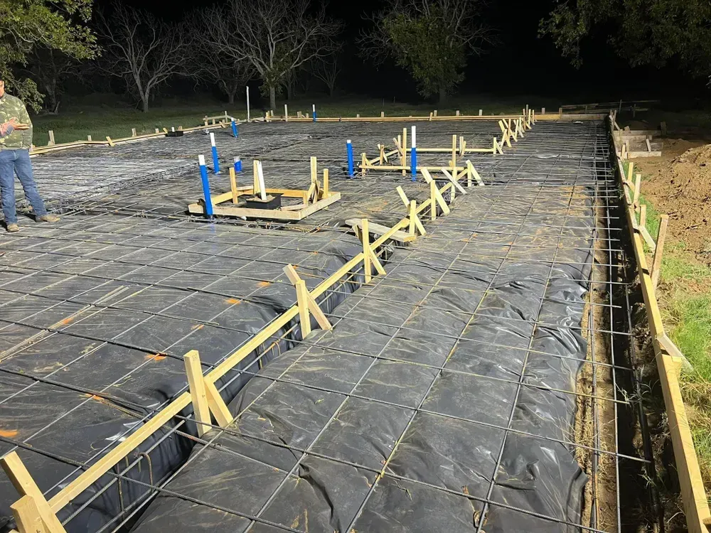 A man is standing on a construction site at night.