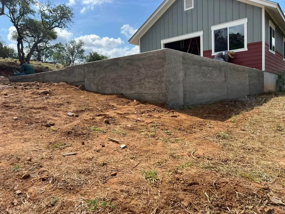 A house is being built on top of a dirt hill.