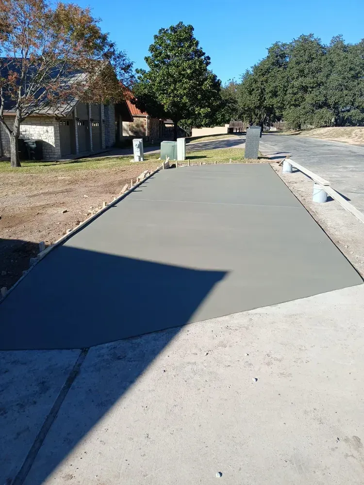 A concrete driveway is being built in front of a house