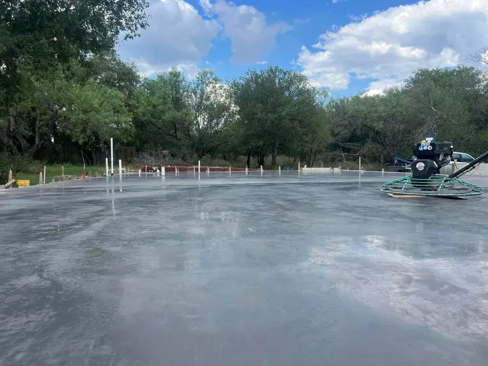 A person is working on a concrete floor in a parking lot.