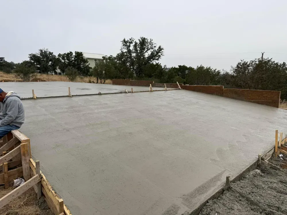 A man is sitting on top of a concrete floor.