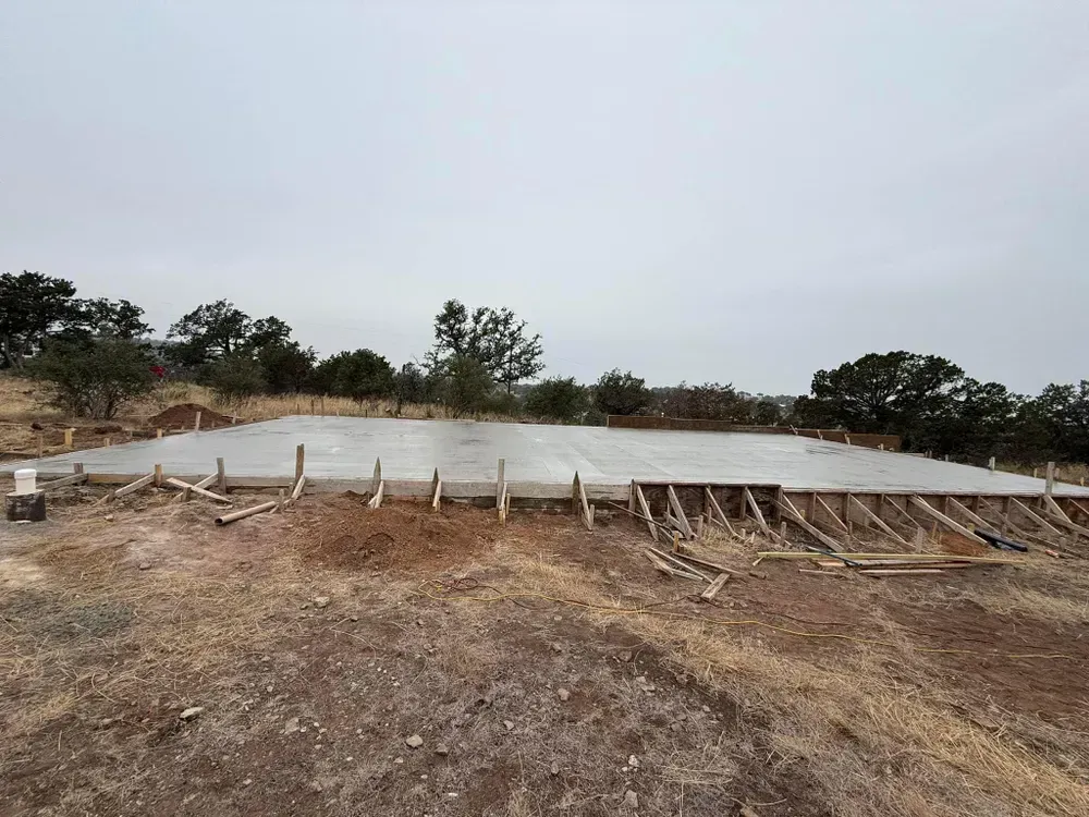 A large concrete slab is sitting in the middle of a dirt field.