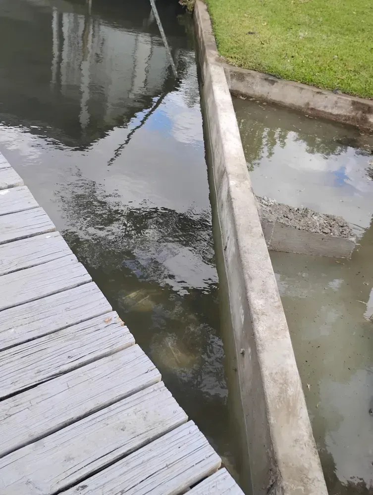 A wooden dock is next to a body of water.