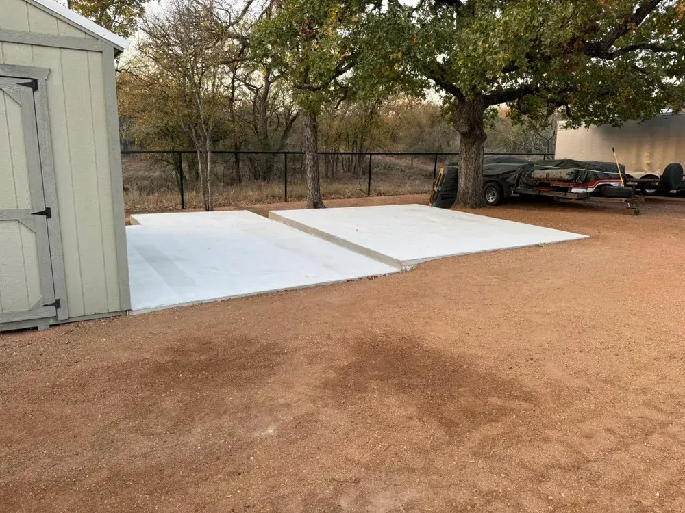 A car is parked in a driveway next to a shed