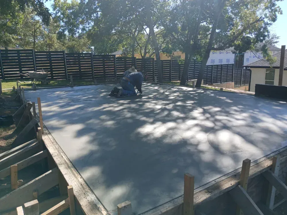 A man is kneeling on a concrete surface.