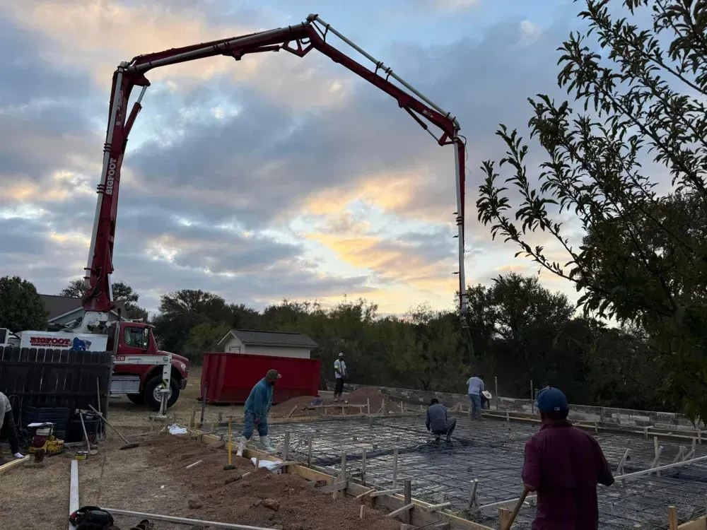 A concrete pump is being used to pour concrete on a construction site