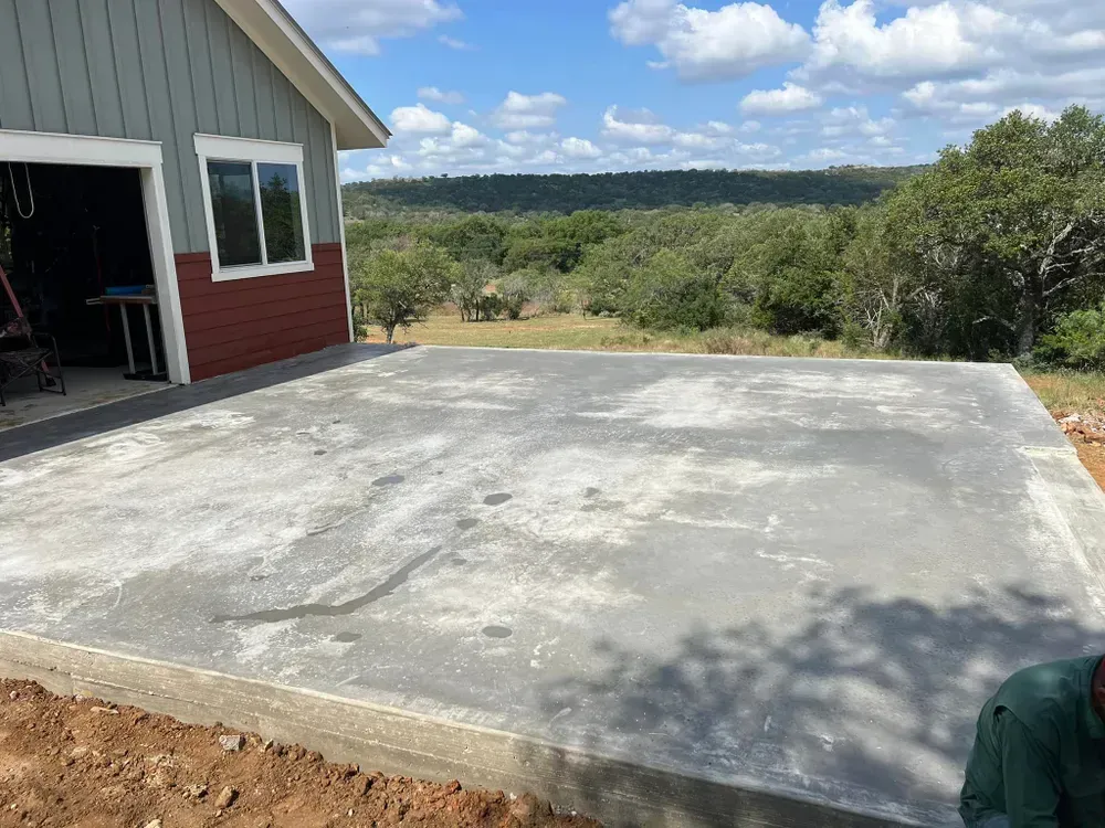 A concrete driveway is being built in front of a house.