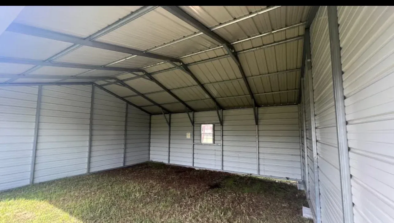 The inside of an empty metal garage with a window.